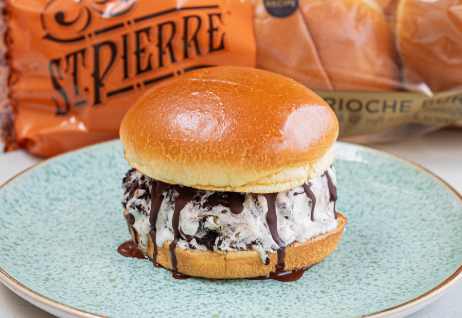 Photo credit: MOB Kitchen A No-Churn Cookies & Cream Ice Cream Burger recipe on a blue plate with St Pierre Burger Buns in the background