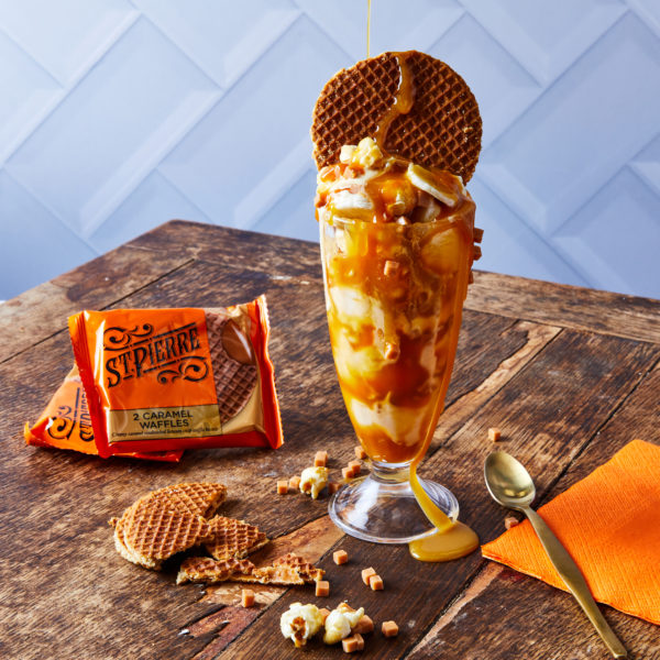 Easter recipe ideas: a photo of a Knickerbocker Glory-style ice cream sundae on a wooden table with broken caramel waffles and sundae spoon next to it